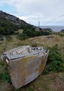 Deteriorating dory fishing boat on land in a meadow