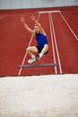 Determination evident in running long jump. Athletic man, sportsman frozen in air, following rules, completed perfect Royalty Free Stock Photo