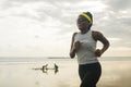 Determined African American woman running on the beach - young attractive and athletic black girl training outdoors doing jogging Royalty Free Stock Photo