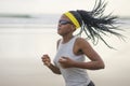 Determined African American woman running on the beach - young attractive and athletic black girl training outdoors doing jogging Royalty Free Stock Photo