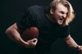 Determined American football player in action isolated on black background Royalty Free Stock Photo