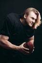 Determined American football player in action isolated on black background Royalty Free Stock Photo