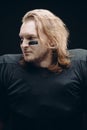 Determined American football player posing with painted face and chewing gum Royalty Free Stock Photo