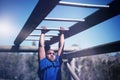 Determined boy exercising on monkey bar during obstacle course Royalty Free Stock Photo