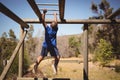 Determined boy exercising on monkey bar during obstacle course Royalty Free Stock Photo