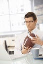 Determined businessman in office with football Royalty Free Stock Photo