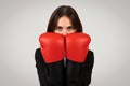 Determined businesswoman with a focused gaze wearing boxing gloves, symbolizing empowerment Royalty Free Stock Photo