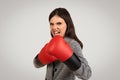 Fierce businesswoman with boxing gloves, ready to fight