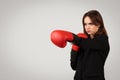 A determined businesswoman wearing boxing gloves adopts a fighting stance Royalty Free Stock Photo