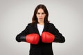 Determined professional woman with a focused gaze wearing red boxing gloves Royalty Free Stock Photo