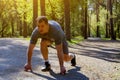 Determined Caucasian sprinter preparing to start racing on road in park Royalty Free Stock Photo