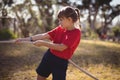 Determined girl practicing tug of war during obstacle course