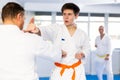 Young karate fighter working on punches in sparring with master at training