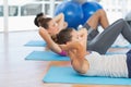 Determined people doing sit ups in fitness studio