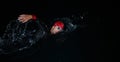A determined professional triathlete undergoes rigorous night time training in cold waters, showcasing dedication and Royalty Free Stock Photo