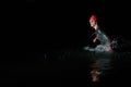 A determined professional triathlete undergoes rigorous night time training in cold waters, showcasing dedication and Royalty Free Stock Photo