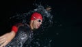 A determined professional triathlete undergoes rigorous night time training in cold waters, showcasing dedication and Royalty Free Stock Photo