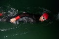 A determined professional triathlete undergoes rigorous night time training in cold waters, showcasing dedication and Royalty Free Stock Photo