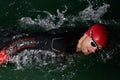 A determined professional triathlete undergoes rigorous night time training in cold waters, showcasing dedication and Royalty Free Stock Photo