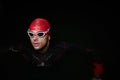 A determined professional triathlete undergoes rigorous night time training in cold waters, showcasing dedication and Royalty Free Stock Photo