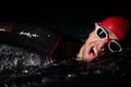 A determined professional triathlete undergoes rigorous night time training in cold waters, showcasing dedication and Royalty Free Stock Photo