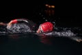 A determined professional triathlete undergoes rigorous night time training in cold waters, showcasing dedication and Royalty Free Stock Photo