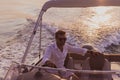 A determined senior businessman in casual clothes and sunglasses enjoys his vacation driving a luxury boat at sunset Royalty Free Stock Photo