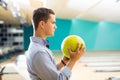 Determined Teenage Boy Holding Yellow Bowling Ball At Alley