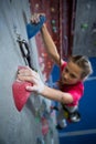 Determined teenage girl practicing rock climbing