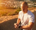 Determined to beat his personal best. a young man checking his sports watch while out running. Royalty Free Stock Photo