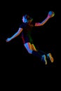 Determined woman, handball player in action, exhibiting focus and energy during training against black background in