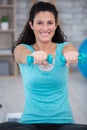 determined woman losing weight at home and exercising with dumbbells