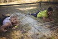Determined women crawling under the net during obstacle course