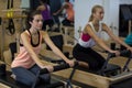 Determined women practicing stretching exercise on reformer