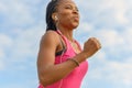 Determined young African woman working out jogging