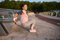 Determined young sportswoman enjoying her morning workout outdoor, doing exercises on triceps, flexing her arms on a wooden bench Royalty Free Stock Photo