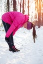 Determined young woman stretching after a workout on cold winter day Royalty Free Stock Photo