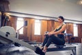 Determined young woman working out on row machine in fitness studio Royalty Free Stock Photo