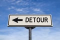 Detour road sign, arrow on blue sky background