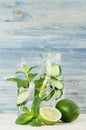 Detox fitness mineral water with cucumber, lime, mint and straw and bottle on soft shabby wood background, closeup. Royalty Free Stock Photo