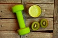 Detox food with kiwi smootie and a green lifting weight