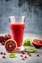 Detox fresh juice or smoothie in glass with blood oranges, greens, pomegranate. Homemade refreshing fruit beverage. Copy space. Royalty Free Stock Photo