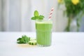 detox green shake with cucumber and celery sticks on side