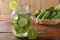 Detox water with lime and cucumbers in a mason jar against a rustic wood background Royalty Free Stock Photo