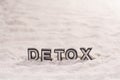 Detox word on white sand