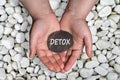 Detox word in stone on hand