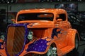 Close-up of a 1933 34 Ford hot rod with custom painted flames, at Detroit Autorama