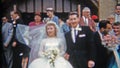 DETROIT, MICHIGAN 1957: Newlywed couple leaving church kissing and celebration.