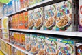 Grocery store shelf with boxes of various brands of breakfast cereal.