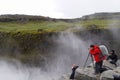 Unidentified tourists taking pictures at Dettifoss in summer, Iceland.